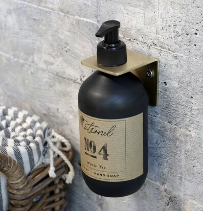 Bild av stilren väggupphängd glasflaska i mässing