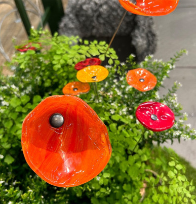 Foto av dekorativa glasblommor i trädgårdsmiljö