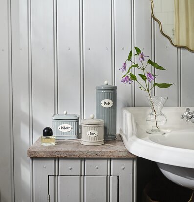 Bild av stilrent badrum med charmiga förvaringslösningar