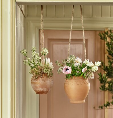Bild av två hängande terrakottakrukor med växter