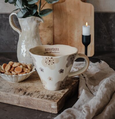 Bild av harmonisk scen med mugg och ljusarrangemang