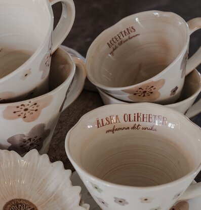 Bild av harmoniska muggar och skålar med blommotiv