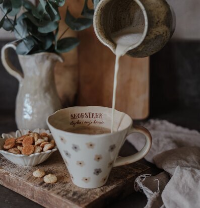 Bild av hemtrevlig scen med mugg och gyllene kex