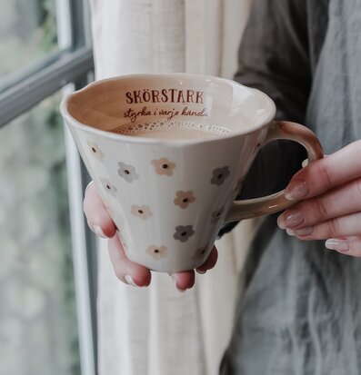 Bild av en elegant mugg med blommönster i hemtrevlig miljö