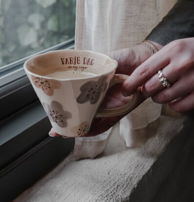 Bild av mugg med blommor och inspirerande text