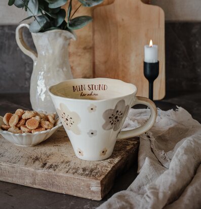 Bild av en stämningsfull uppsättning med mugg och ljus