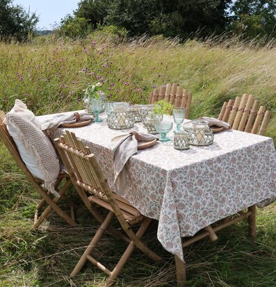 Bild av lantlig dukning med blommig bordsduk utomhus