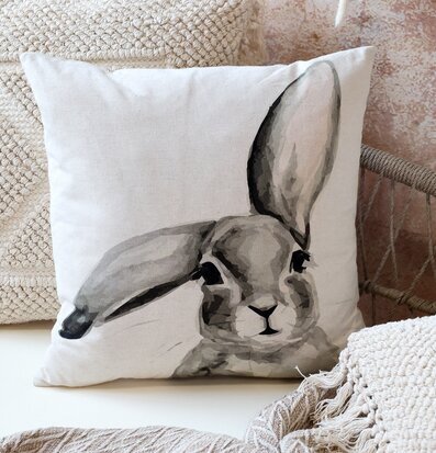 Bild av kuddfodral med kaninmotiv i hemtrevlig miljö