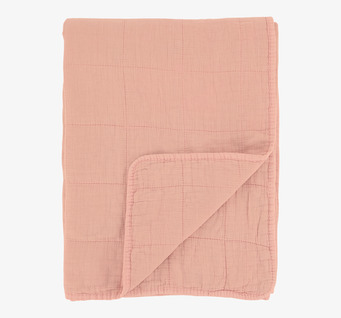 Bild av en rosa pläd med mjukhet och komfort i fokus