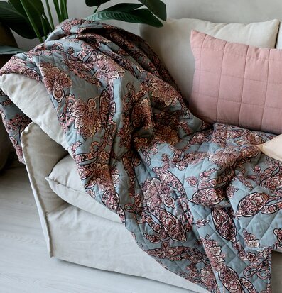 Bild av mysig soffa med paisleypläd och kuddar