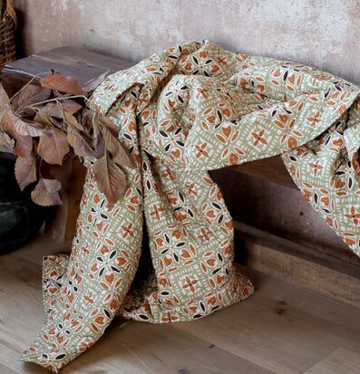 Bild av pläd i harmoniska jordtoner och geometriskt mönster