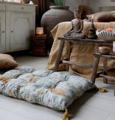 Bild av harmoniskt rum med golvmadrass och Buddha-statyer