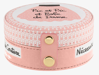 Bild av rund sybox med rosa design och gulddetaljer