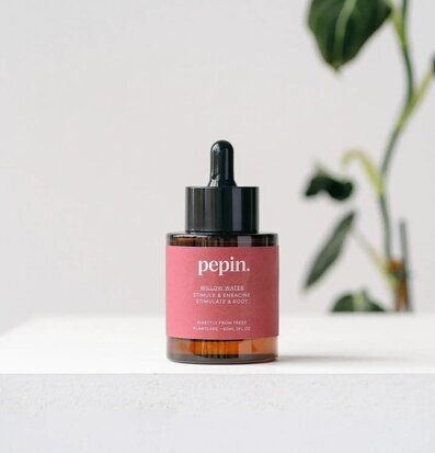 Bild av stilren flaska för rotutveckling och växtvård