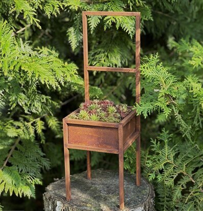 Bild av kreativ och rustik planteringstol i naturen