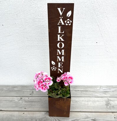 Bild av dekorativ välkommenskylt med blommor och löv