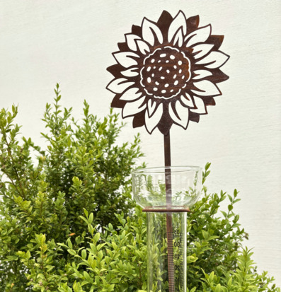 Bild av regnmätare med solrosdesign i trädgårdsmiljö