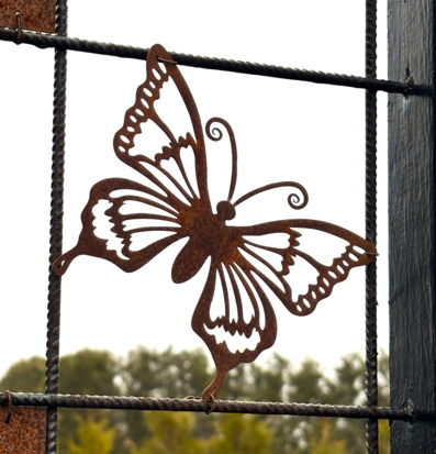 Bild av dekorativ fjäril på armeringsnät i trädgård