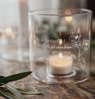 Bild av glaslykta med blommotiv och text för barnarbete