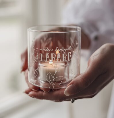 Bild av glaslykta med text till lärare och varma växtmotiv