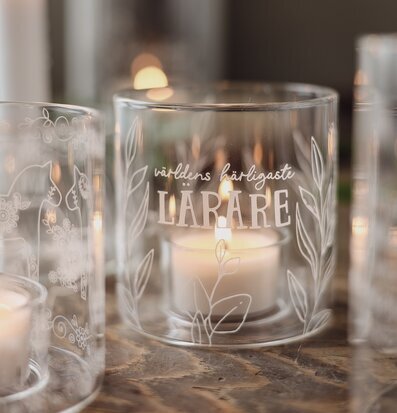 Bild på elegant ljuslykta med gravyr och värmeljus i glas