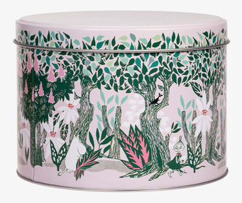 Bild av rund plåtburk med färgstarkt muminmotiv och vårskog