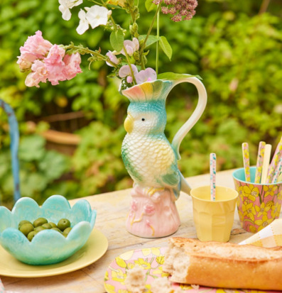 Bild: Somrig utomhusdukning med färgstark kanna och porslin