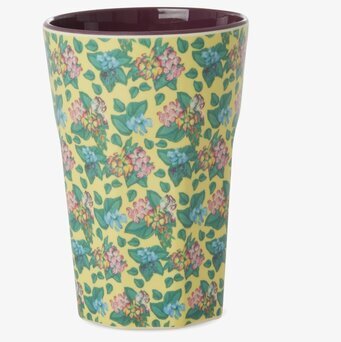 Bild på latte-mugg med blommor, blad och lila insida