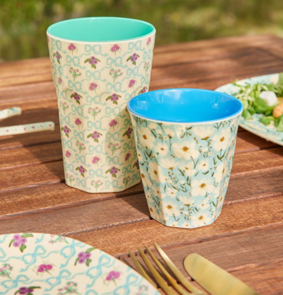 Bild av färgglada somriga muggar på träbord utomhus