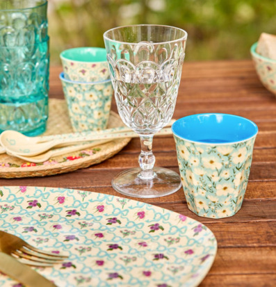 Bild av färgglad utomhusdukning med blommigt porslin och glas