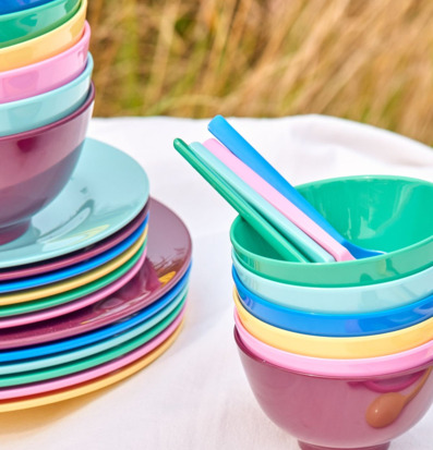 Bild av färgglada tallrikar och skålar för picknick och hem