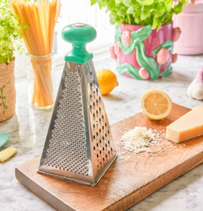 Bild av ljust kök med rivjärn, ost och färska örter