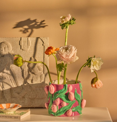 Bild på harmonisk inredning med rosa blomkruka och relieff