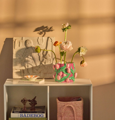 Bild: Modern hylla med konst, böcker och färgstark blomkruka