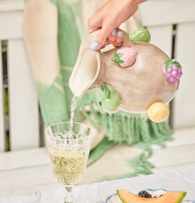 Bild av dukat bord med stengodskanna och färgglada detaljer