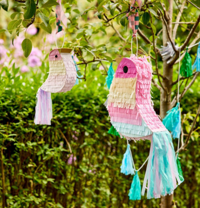 Bild på färgglada piñator och pappersdekorationer i trädgård