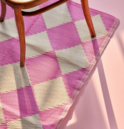 Bild av schackrutig plastmatta och trästol i ljusrosa rum