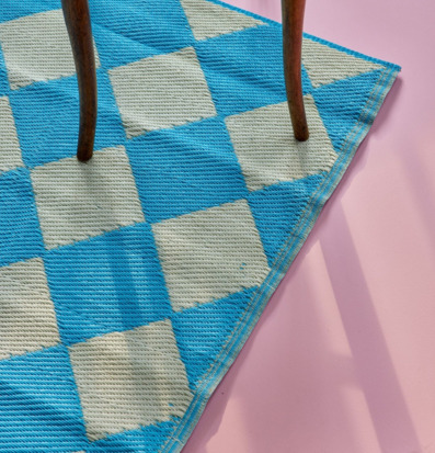 Bild av harlequinmönstrad matta och trästol i ljus interiör