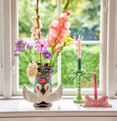 Bild av fönsterbräda med blommor och dekor i mjuka pasteller