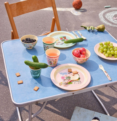 Bild av färgglad picknickdukning med barnvänlig servis ute