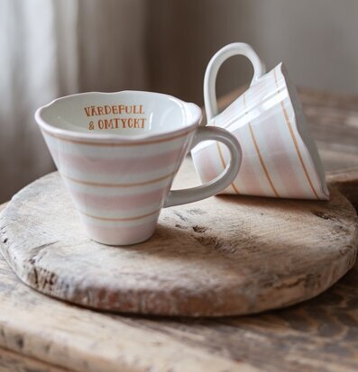 Bild med två koniska muggar i varm och hemtrevlig miljö