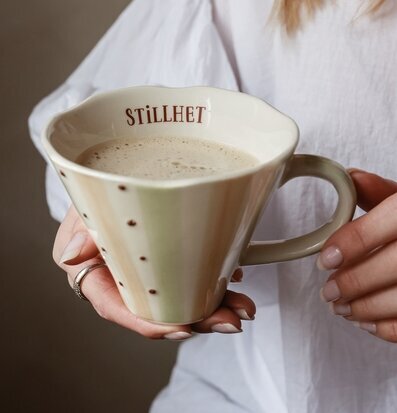 Bild av stilren mugg med skumdryck och rofylld atmosfär