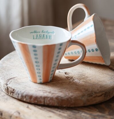 Bild av två konformade muggar med lekfullt randigt mönster