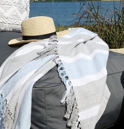 Bild av somrig utomhusmiljö med textilier och naturtoner