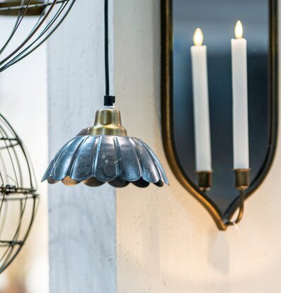 Bild av industriell taklampa och spegel i ljus interiör