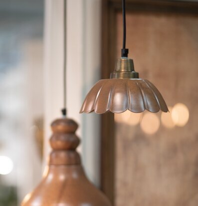 Bild på två taklampor i varmbrun metall och mjuk belysning