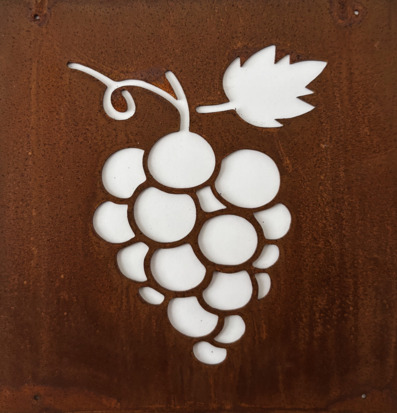 Bild på dekorativ skylt med vindruvsmotiv i rostig metall