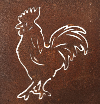 Bild på rostig metallskylt med utskuren tuppsiluett