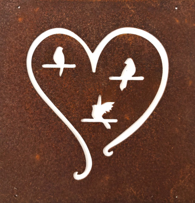 Bild på rostig metallskylt med hjärta och fåglar utskuret