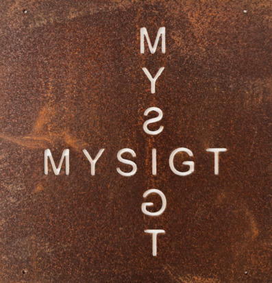 Bild av rostig metallskylt med texten MYSIGT i korsformat